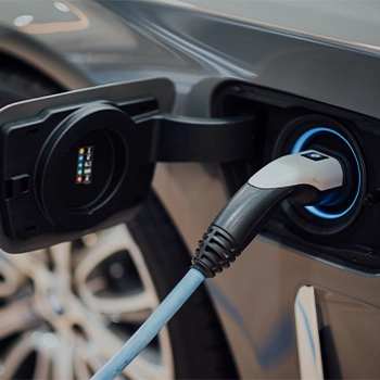 Grey electric car plugged in and charging
