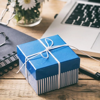 Blue gift box on a work desk with laptop