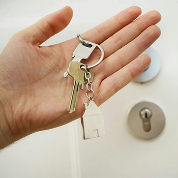 Hand holding keys in front of a door