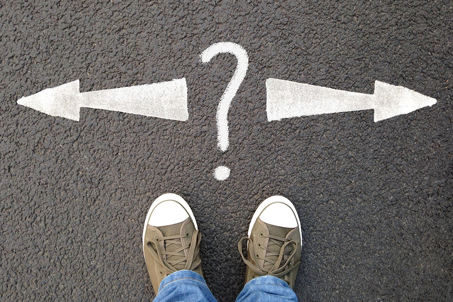 Point of view looking at a road with arrows pointing left and right, with a question mark in the middle.
